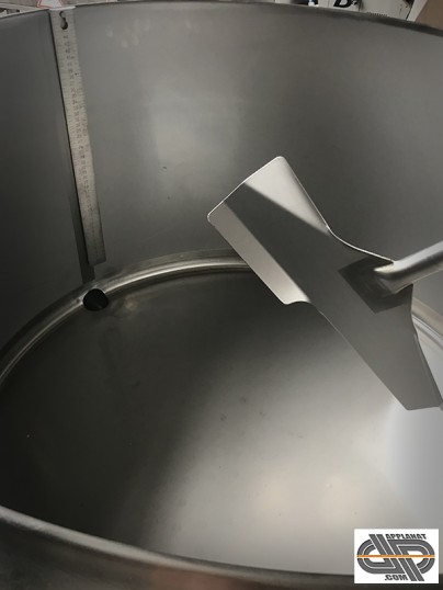 Détail sur l'intérieur de cuve d'un tank a lait avec mélangeur de brassage visible et réglet gradué suspendu