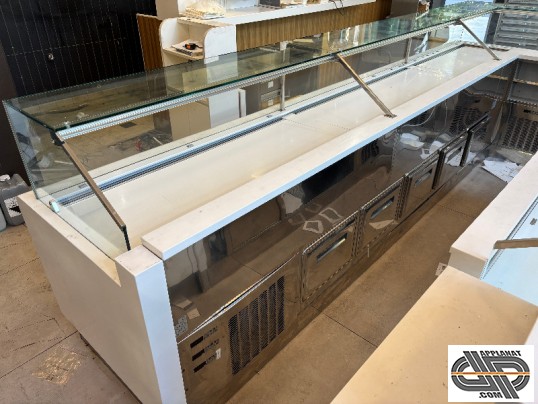 Vue côté service d'une grande vitrine de boutique traiteur avec réserver réfrigérée