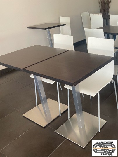 assortiment de tables plateau wengé base inox et tables blanches dans un restaurant