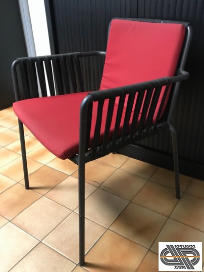 chaise noire avec accoudoir et un coussin rouge